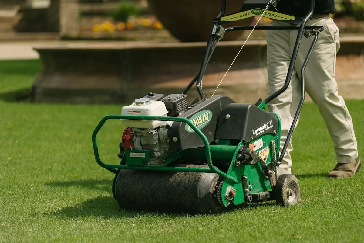 A professional lawn aeration machine being used to loosen compacted soil and improve grass health in Haddon Heights
